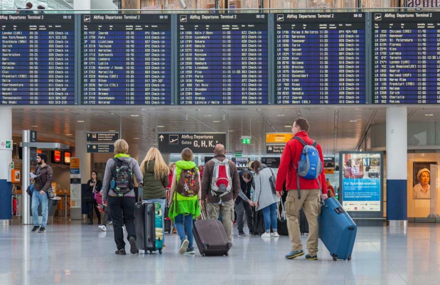 Passengers look at a flight schedule board at Munich Airport. Image: Munich Airport